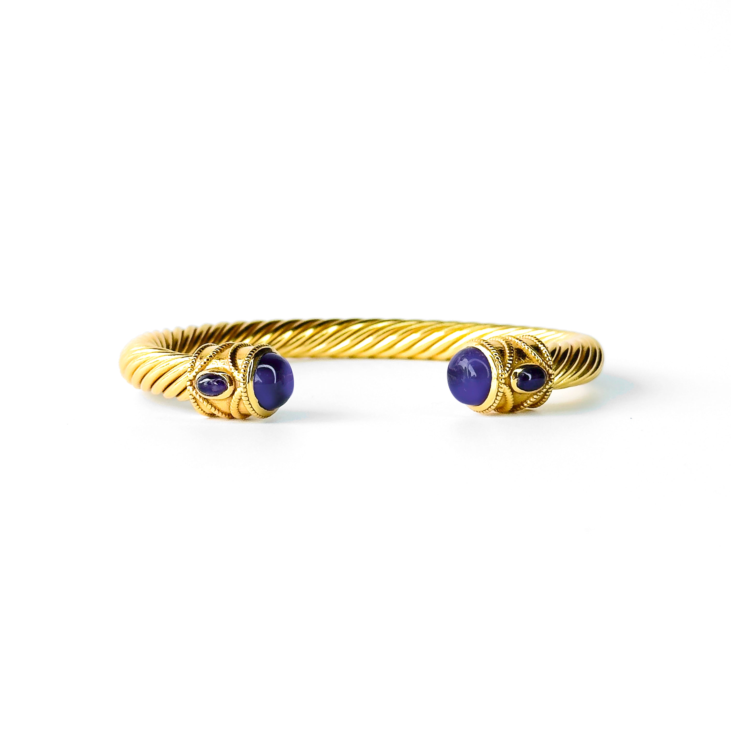 Twisted gold bangle bracelet with purple gemstone end caps