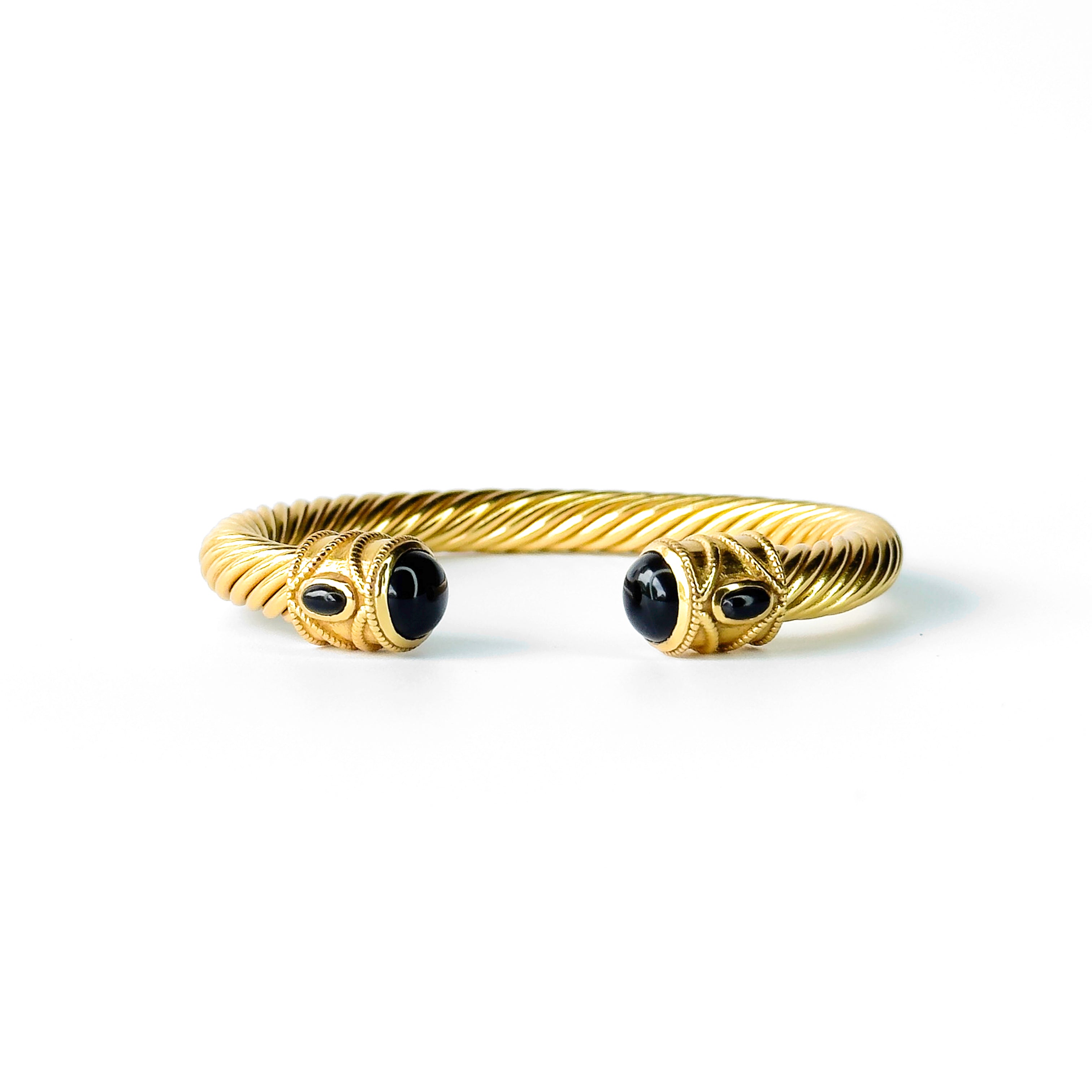 Twisted gold bangle bracelet with black gemstone ends