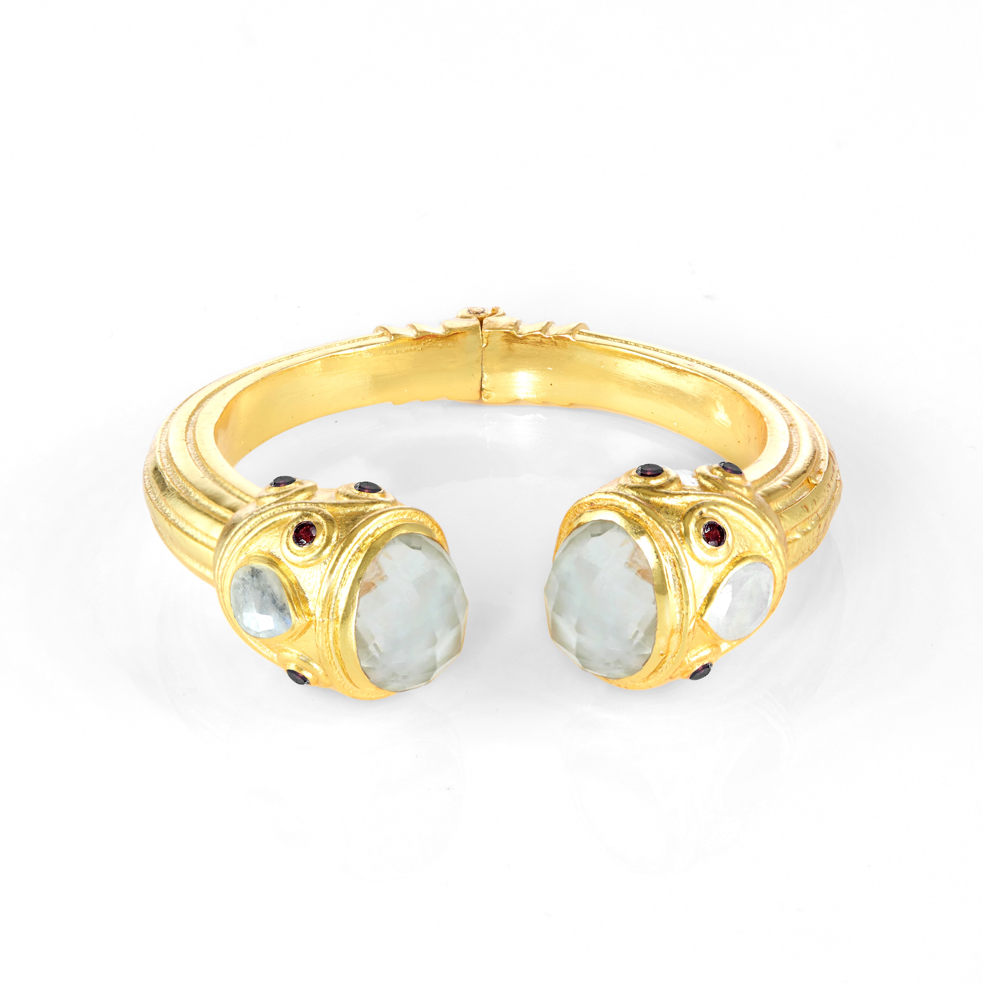 Gold cuff bracelet with pale blue gemstone end settings