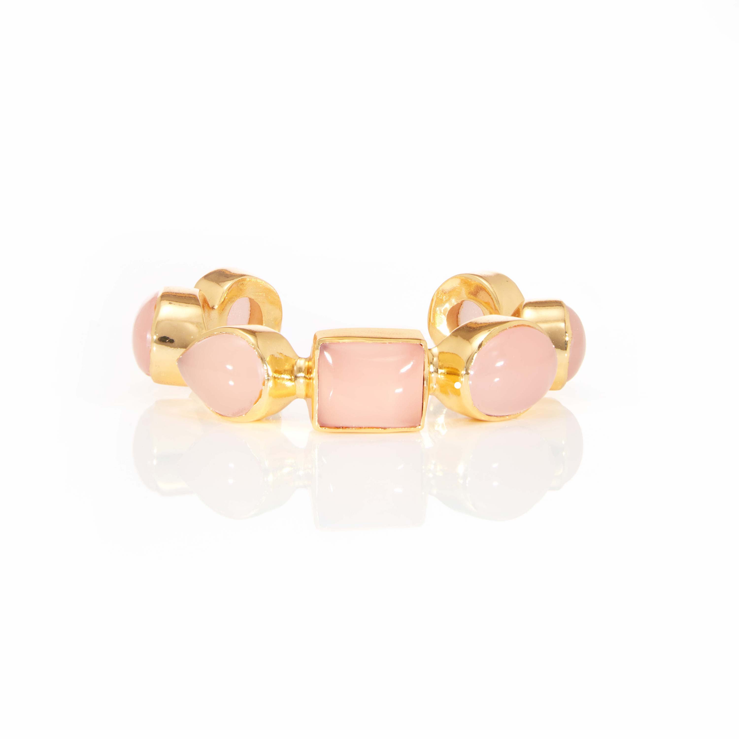 Gold gemstone ring with pink stone centerpiece in polished gold setting